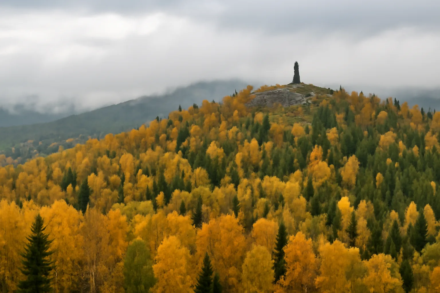 Crête boisée de l'Oural en automne, bouleaux dorés et épicéas, avec un petit obélisque au sommet