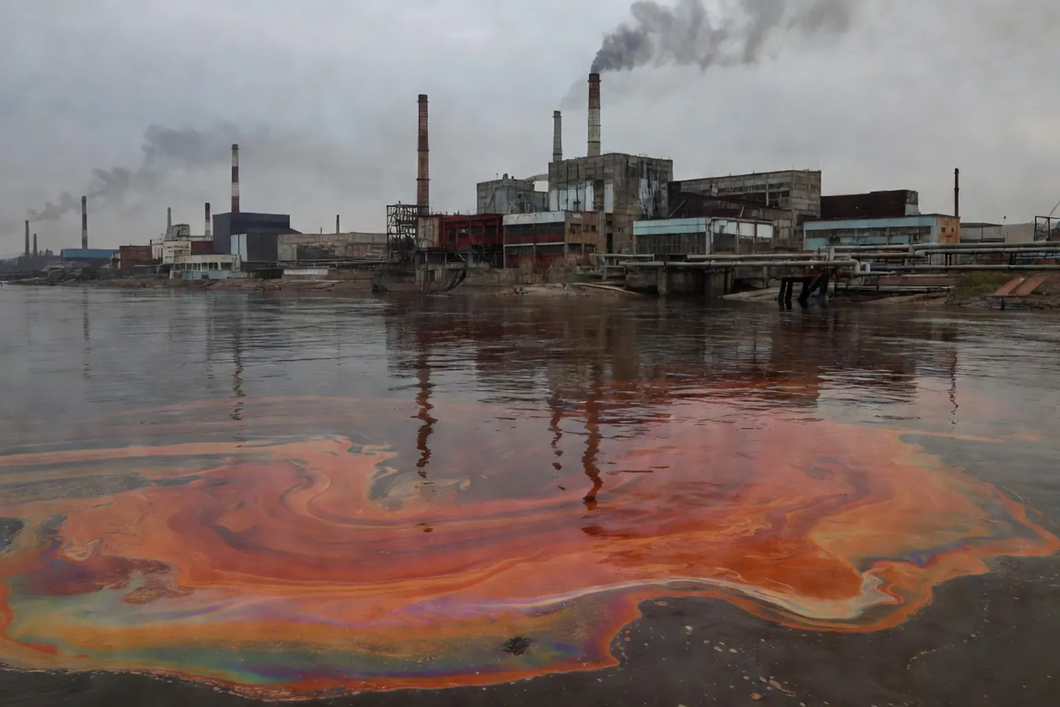 Rivière sibérienne contaminée par des rejets industriels, eau colorée près d'une usine en Russie